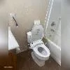 a bathroom with a granite countertop sink a toilet and shower
