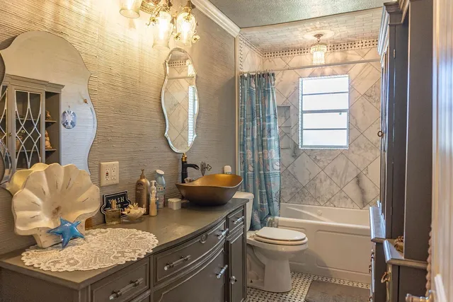 a bathroom with a granite countertop toilet sink and mirror