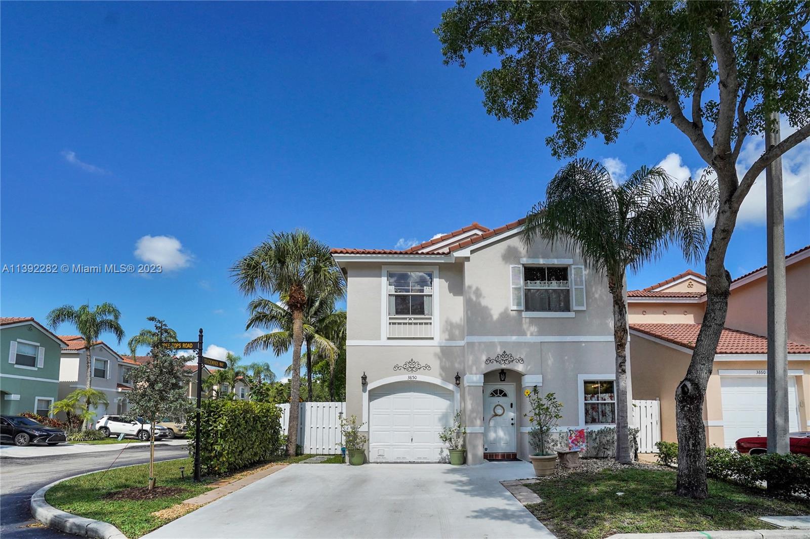 3850 Tree Top Road Cooper City, FL 33026 - Photo 1 of 34 a view of a white house with a tree and plants next to a yard