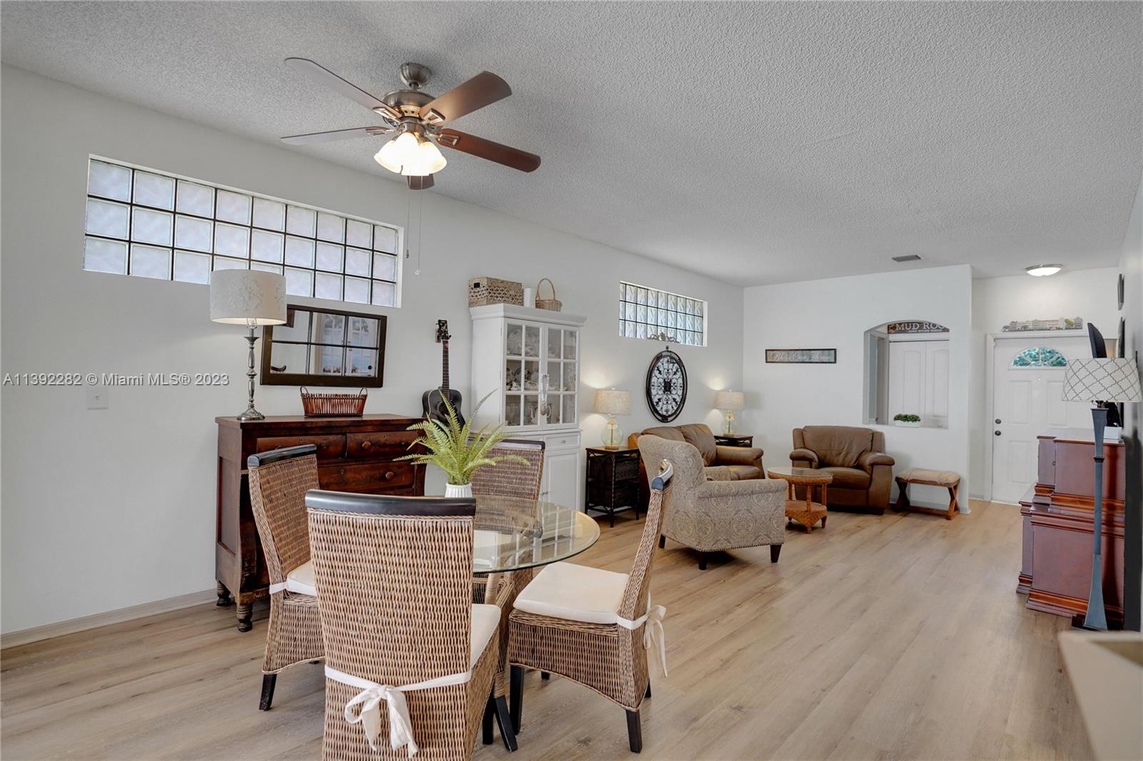 3850 Tree Top Road Cooper City, FL 33026 - Photo 7 of 34 a living room with furniture a fireplace and a chandelier