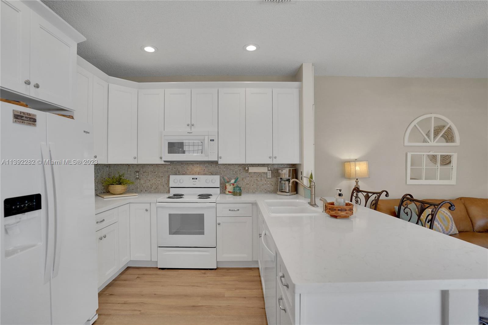 3850 Tree Top Road Cooper City, FL 33026 - Photo 8 of 34 a kitchen with a refrigerator a stove a sink dishwasher and white cabinets with wooden floor