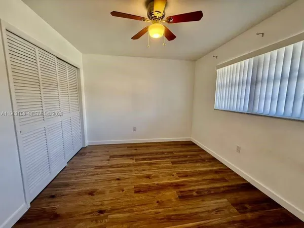 a view of empty room with window and wooden floor
