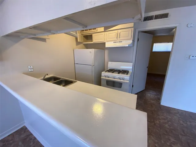 a kitchen with a refrigerator and a stove