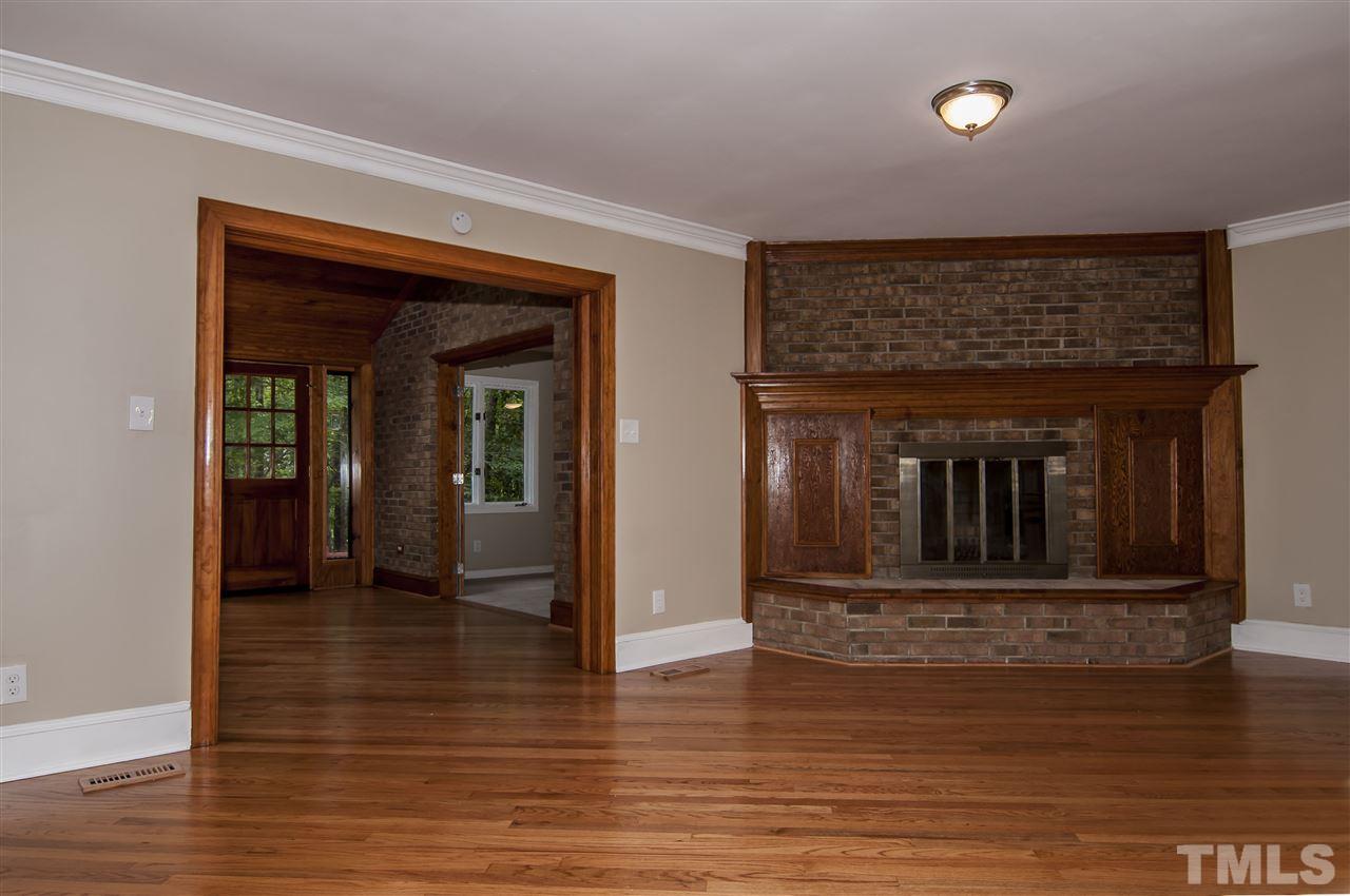 8828 Stage Ford Road Raleigh, NC 27615 - Photo 22 of 25 a view of a hallway with wooden floor and a fireplace
