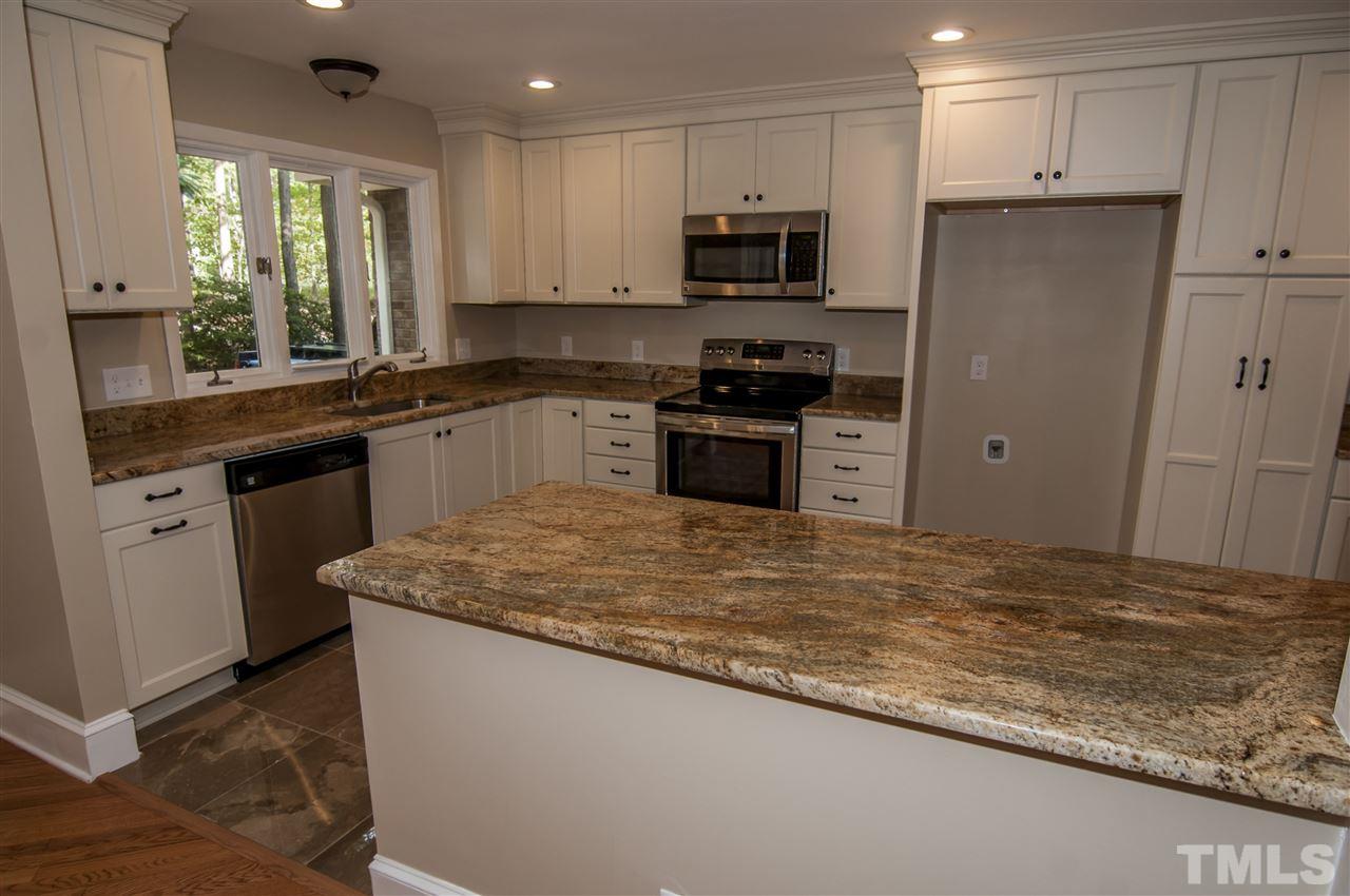 8828 Stage Ford Road Raleigh, NC 27615 - Photo 4 of 25 a kitchen with stainless steel appliances granite countertop a sink stove and refrigerator