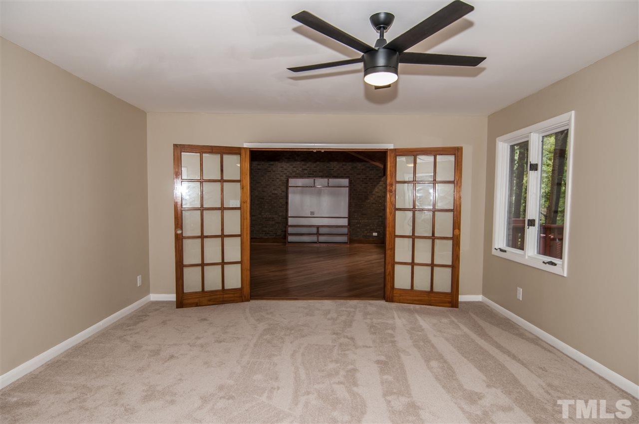 8828 Stage Ford Road Raleigh, NC 27615 - Photo 8 of 25 an empty room with windows and ceiling fan