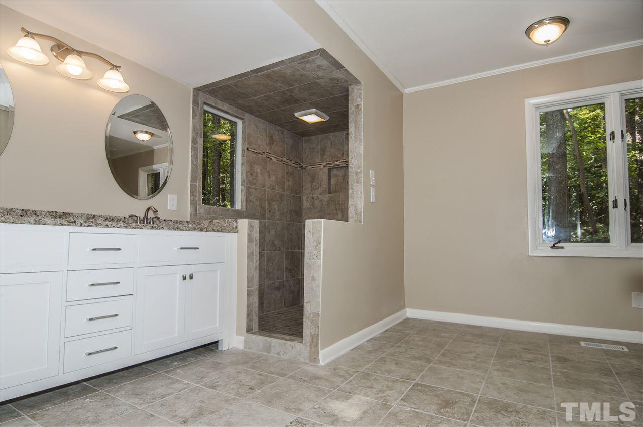 8828 Stage Ford Road Raleigh, NC 27615 - Photo 9 of 25 a bathroom with a granite countertop sink a mirror and a vanity
