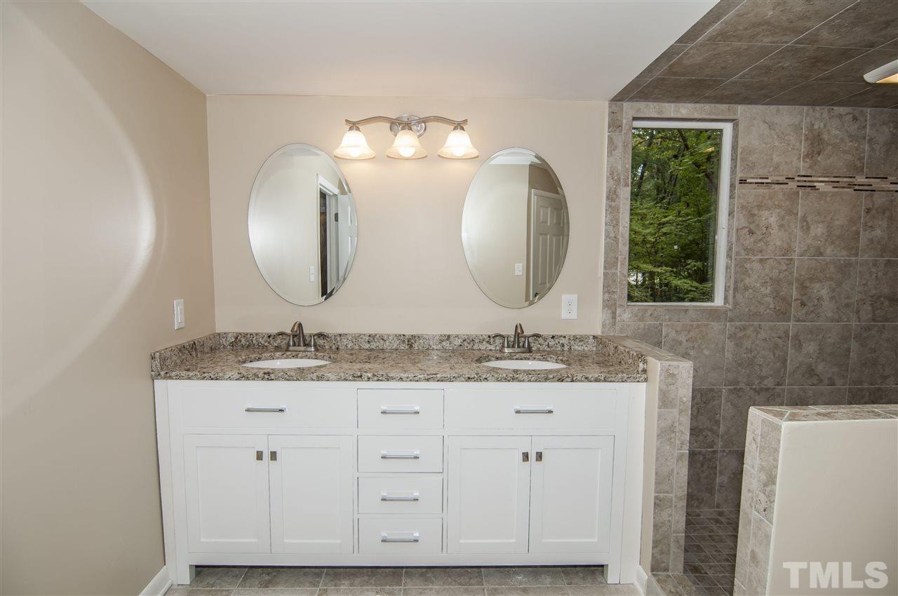 8828 Stage Ford Road Raleigh, NC 27615 - Photo 10 of 25 a bathroom with a double vanity sink and a mirror