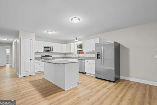 a kitchen with white cabinets and stainless steel appliances
