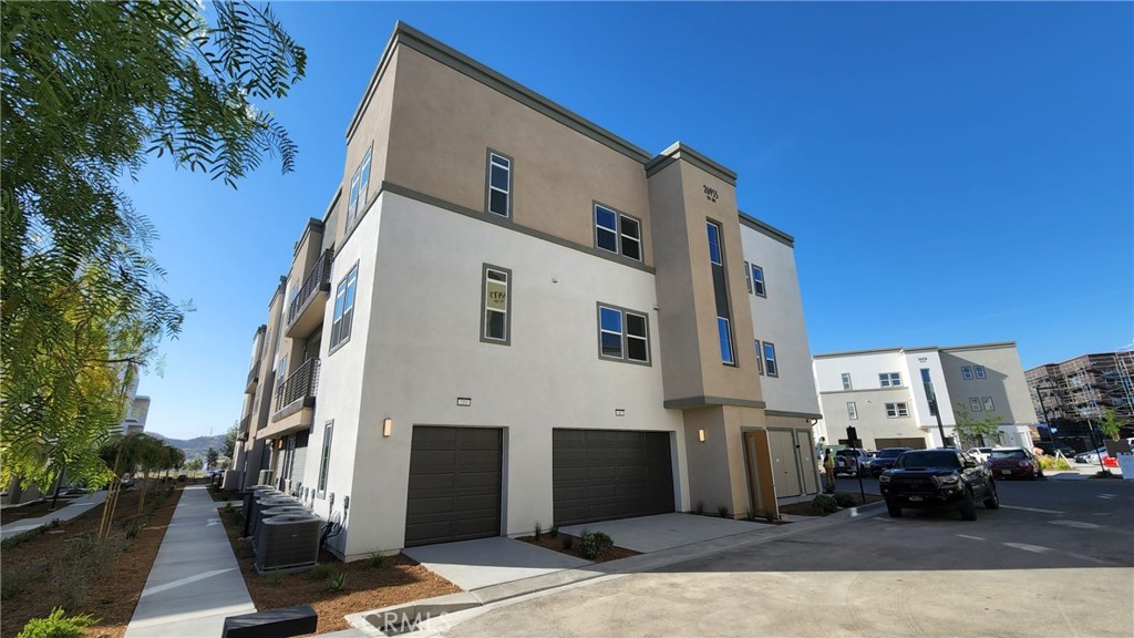 a view of a white building among the street with palm trees
