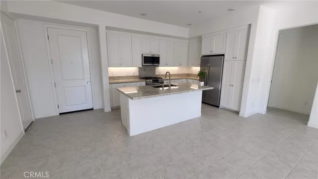 a kitchen with stainless steel appliances granite countertop a stove a sink and a refrigerator