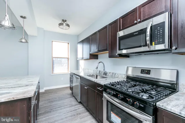 a kitchen with granite countertop counter space a sink appliances and a window