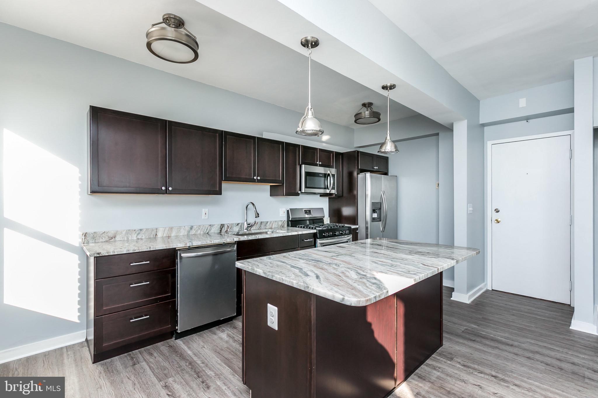 1001 St Paul Street, Unit 6G Baltimore, MD 21202 - Photo 8 of 32 a kitchen with a stove a sink and a refrigerator