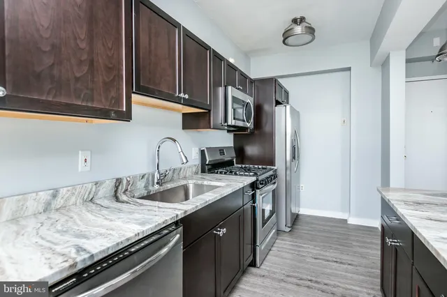 a kitchen with stainless steel appliances granite countertop a stove microwave and oven