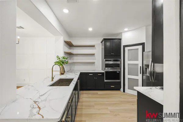 a kitchen with granite countertop a refrigerator and a stove top oven
