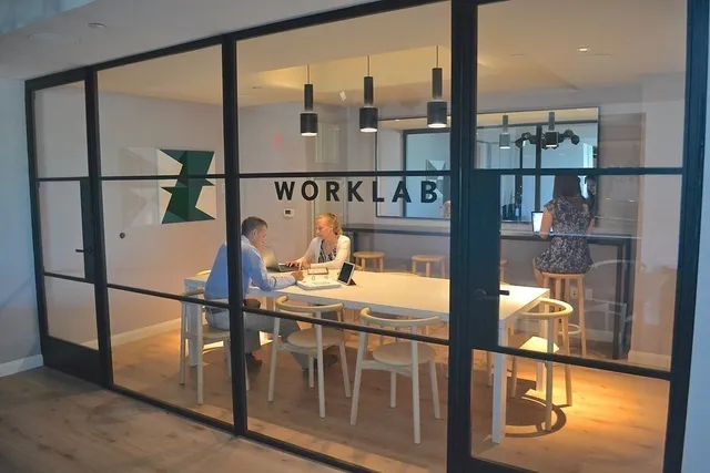 a view of a patio with lawn chairs floor to ceiling window and outdoor kitchen