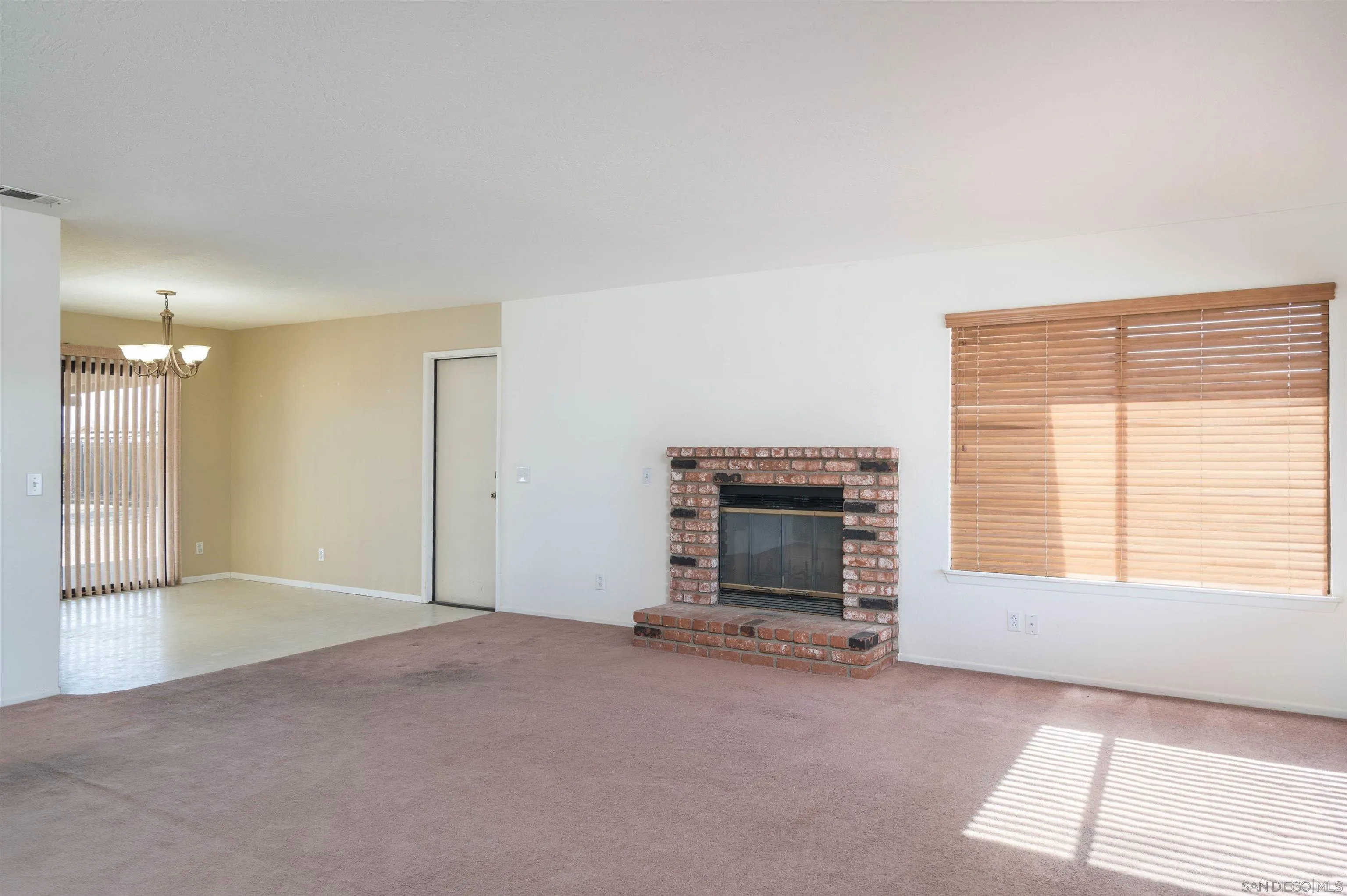 11341 Chimayo Road Apple Valley, CA 92308 - Photo 2 of 27 a view of empty room with a fireplace and a window