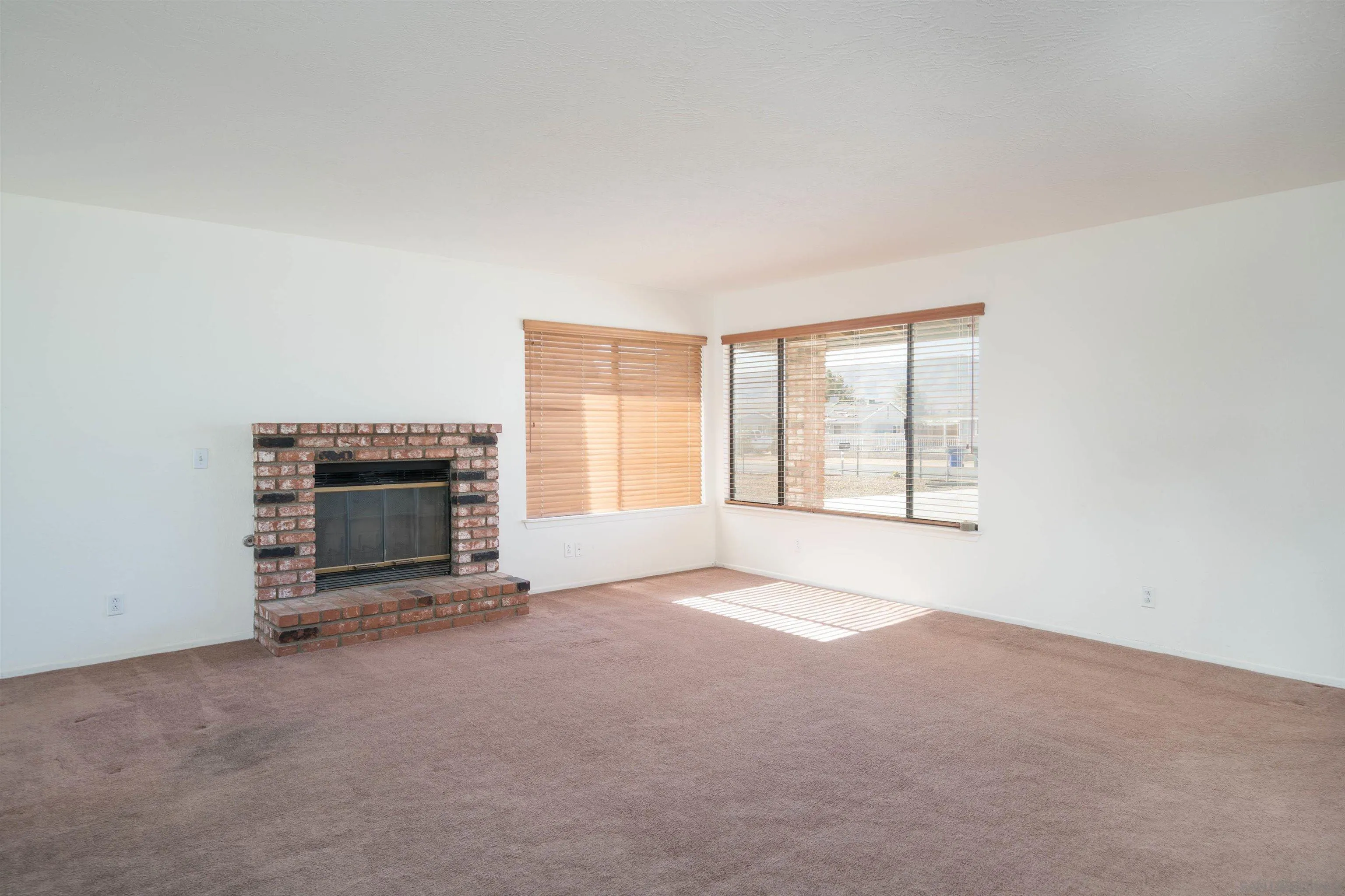 11341 Chimayo Road Apple Valley, CA 92308 - Photo 3 of 27 an empty room with furniture and a fireplace