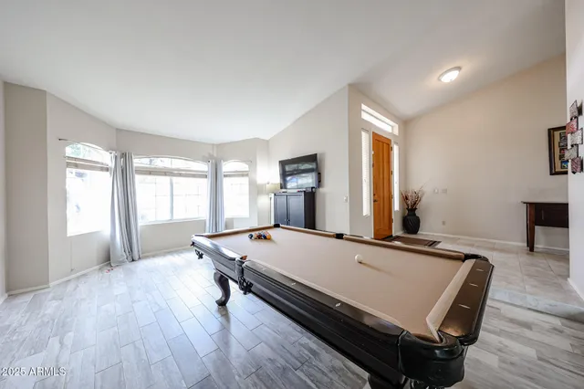 a room with pool table and windows