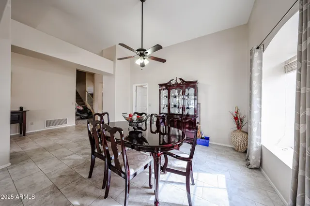 a view of a dining room with furniture and a chandelier fan