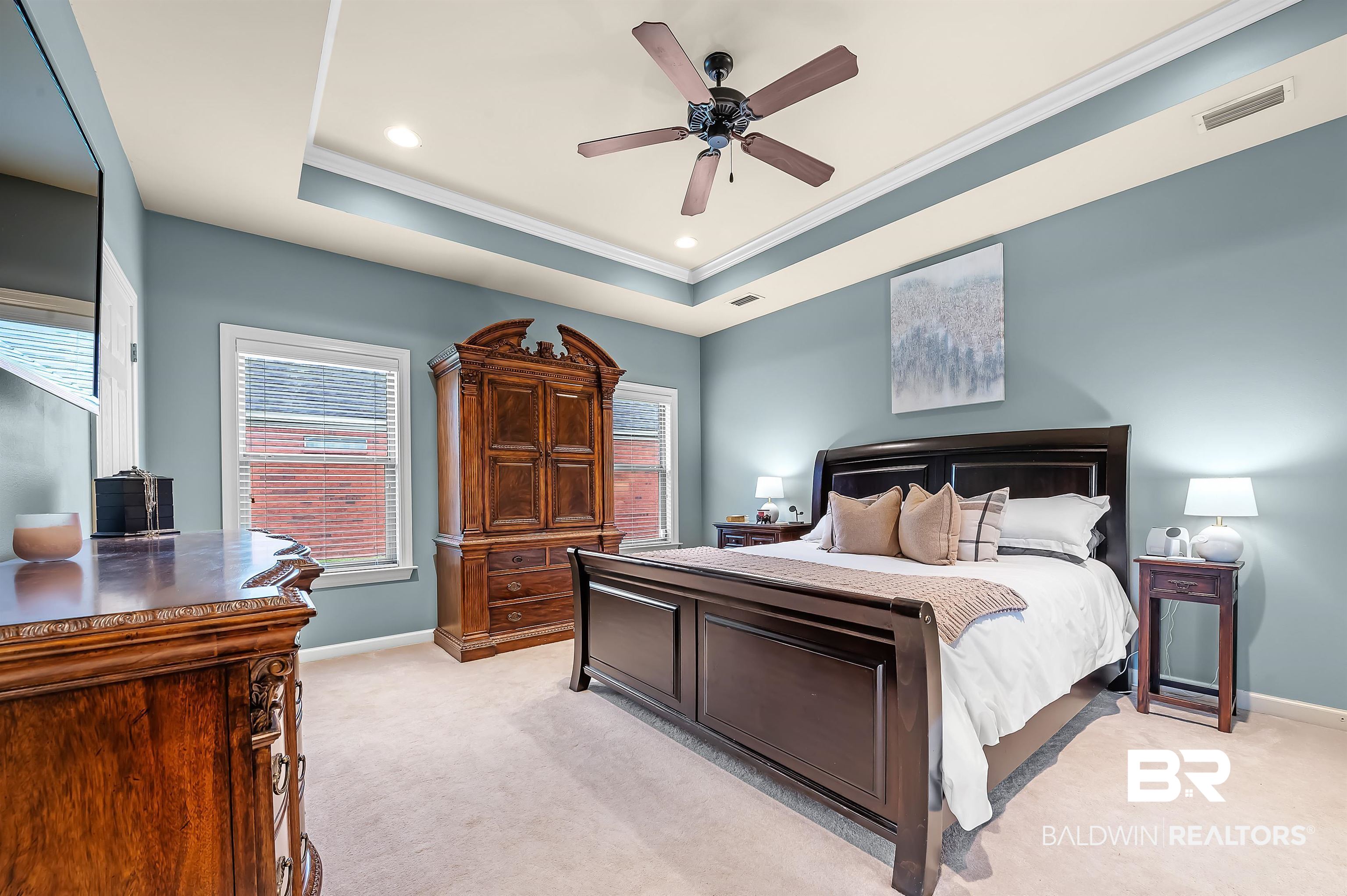 9376 Sable Court Daphne, AL 36526 - Photo 25 of 46 Bedroom with light colored carpet, ceiling fan, ornamental molding, and a tray ceiling