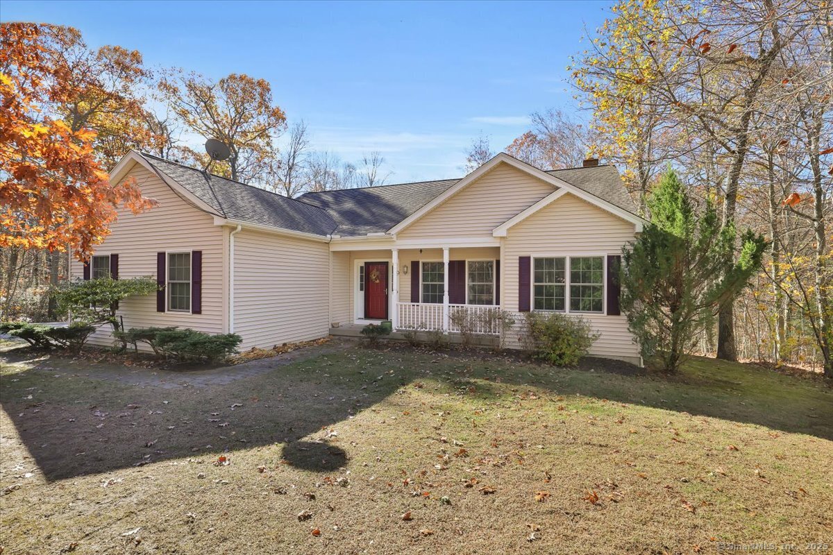 a front view of a house with a yard covered with trees