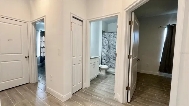 a bathroom with a glass door shower a toilet and a sink