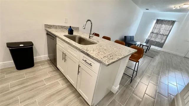 a kitchen with a sink and a wooden floor