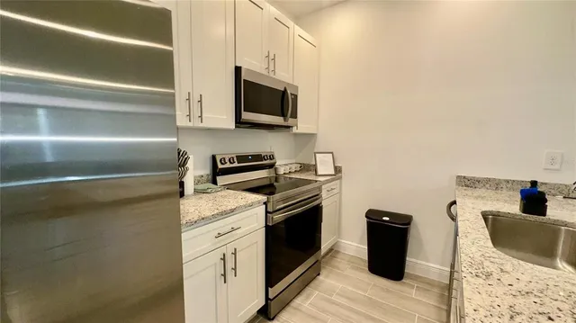 a kitchen with stainless steel appliances granite countertop a stove a microwave and a refrigerator