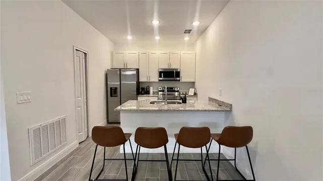 a kitchen with cabinets and chairs