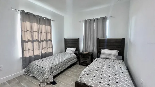 a bedroom with two beds and a window