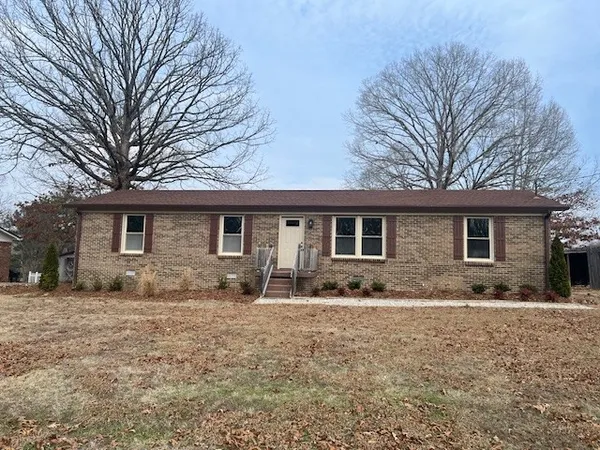 a front view of house with yard covered in snow