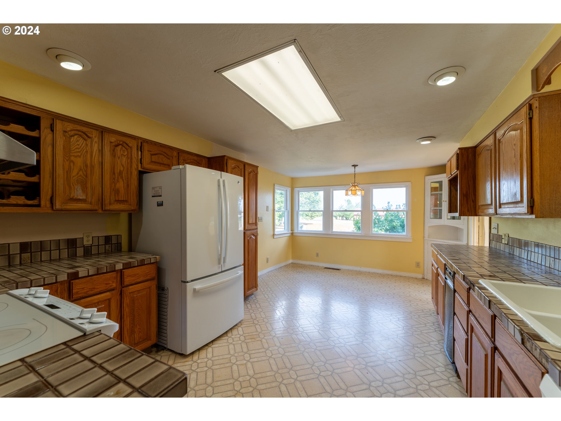 18451 Southeast Lower Island Road Dayton, OR 97114 - Photo 10 of 47 a kitchen with stainless steel appliances granite countertop a refrigerator a sink dishwasher a stove and white countertops with wooden floor
