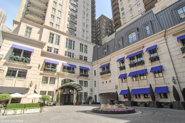 a front view of multi story residential apartment building with retail shops