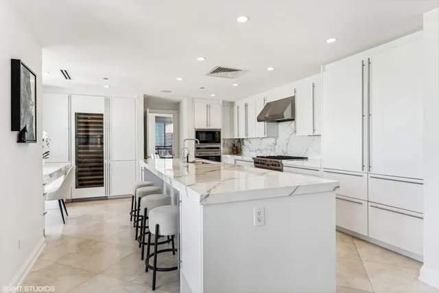 a kitchen with stainless steel appliances kitchen island a refrigerator sink and cabinets