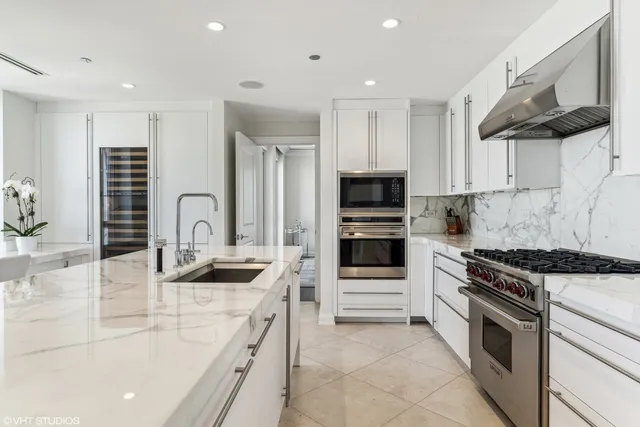 a kitchen with kitchen island granite countertop a sink and stainless steel appliances