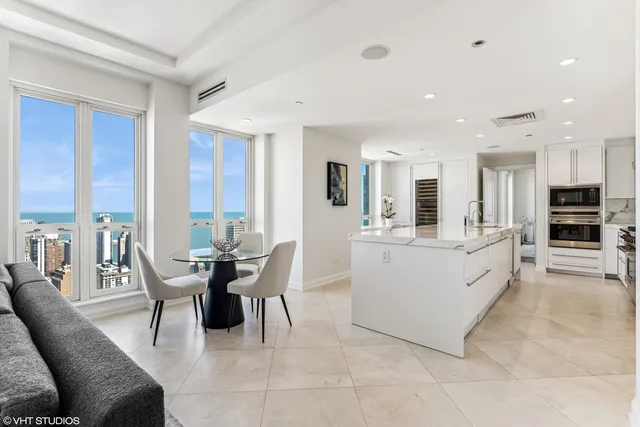 a large white kitchen with furniture a large window and a counter space