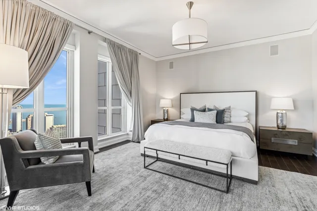 a bedroom with a bed wooden floor and a large window