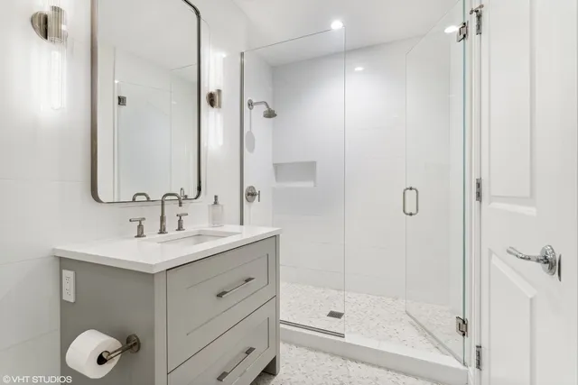 a bathroom with a shower sink vanity and mirror