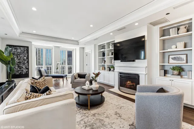 a living room with furniture a flat screen tv and a fireplace