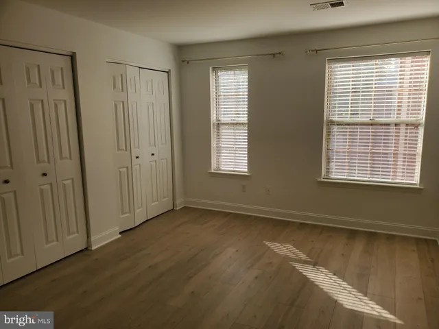 an empty room with wooden floor and closet