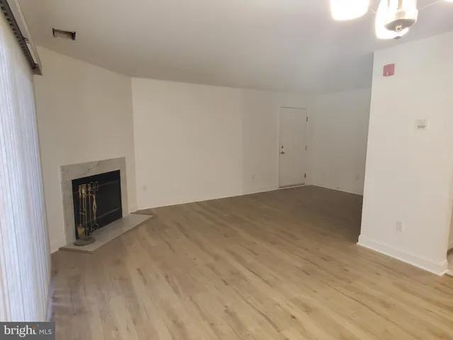 a view of empty room with wooden floor and fireplace