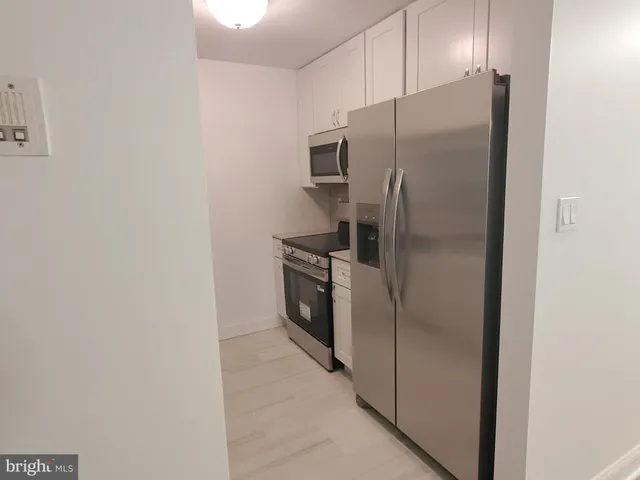 a metallic refrigerator freezer and a stove sitting inside of a kitchen