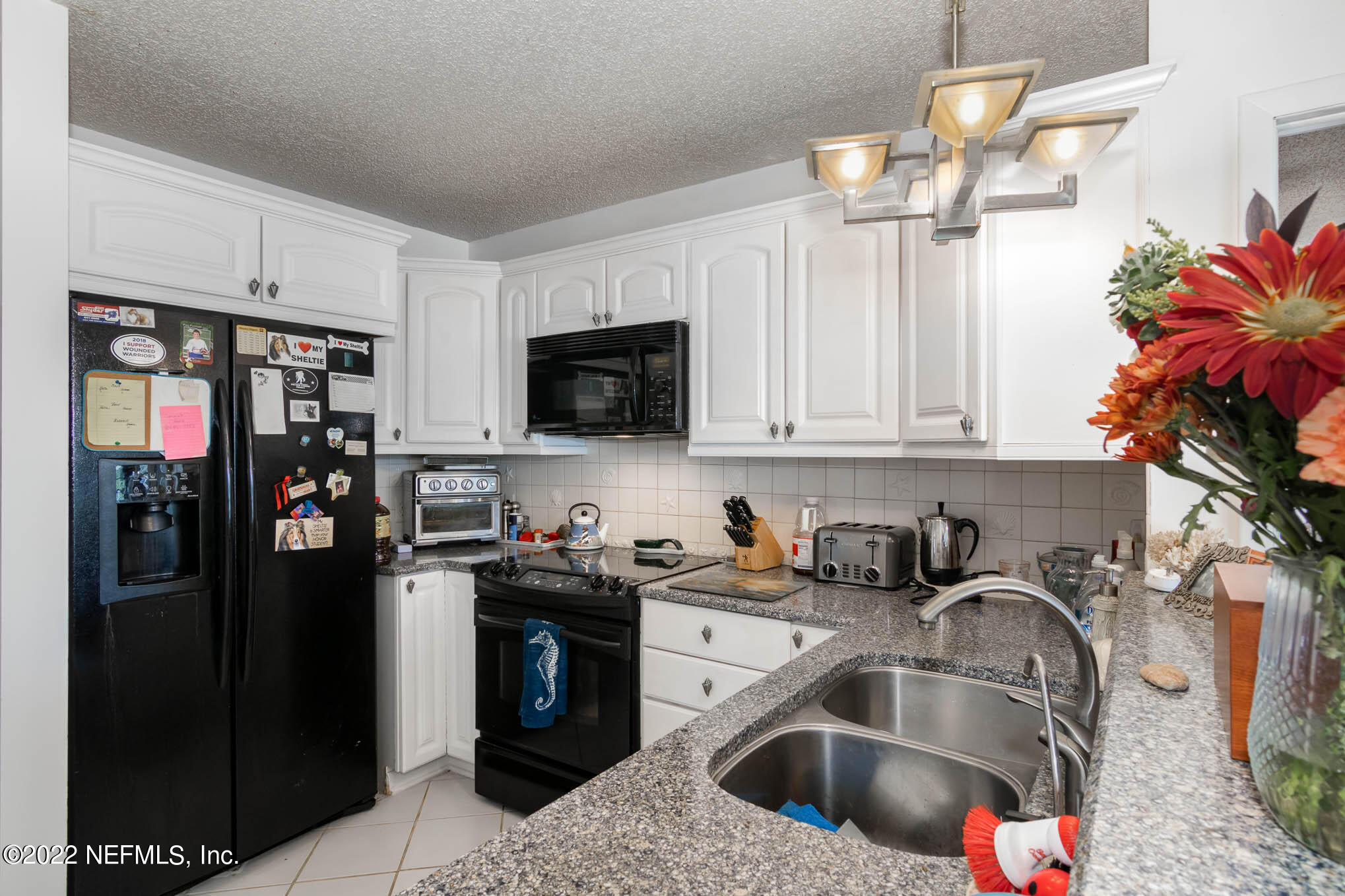 7047 Rivercrest Drive Jacksonville, FL 32226 - Photo 11 of 29 a kitchen with stainless steel appliances granite countertop a refrigerator a sink a stove a dining table and chairs