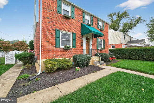 a view of a brick house with a yard and plants