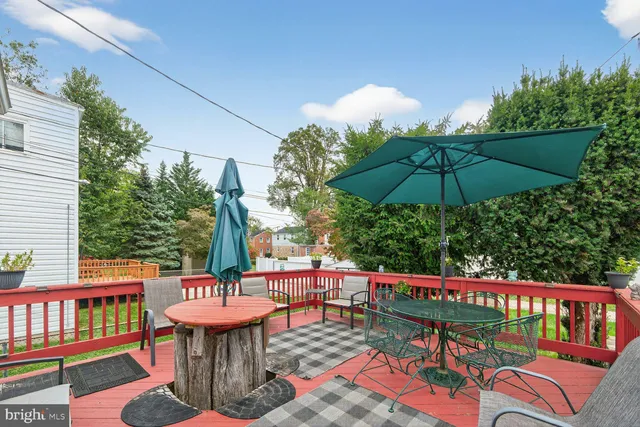 a balcony with wooden floor table and chairs