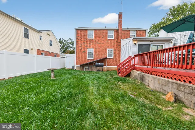 a view of a house with a small yard and deck