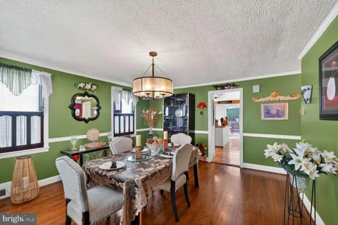 a view of a dining room with furniture a chandelier and wooden floor