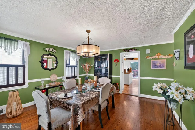 a view of a dining room with furniture a chandelier and wooden floor