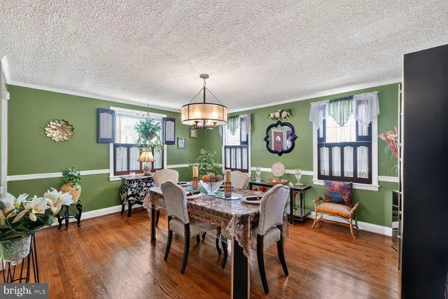 a view of a dining room with furniture a chandelier and wooden floor